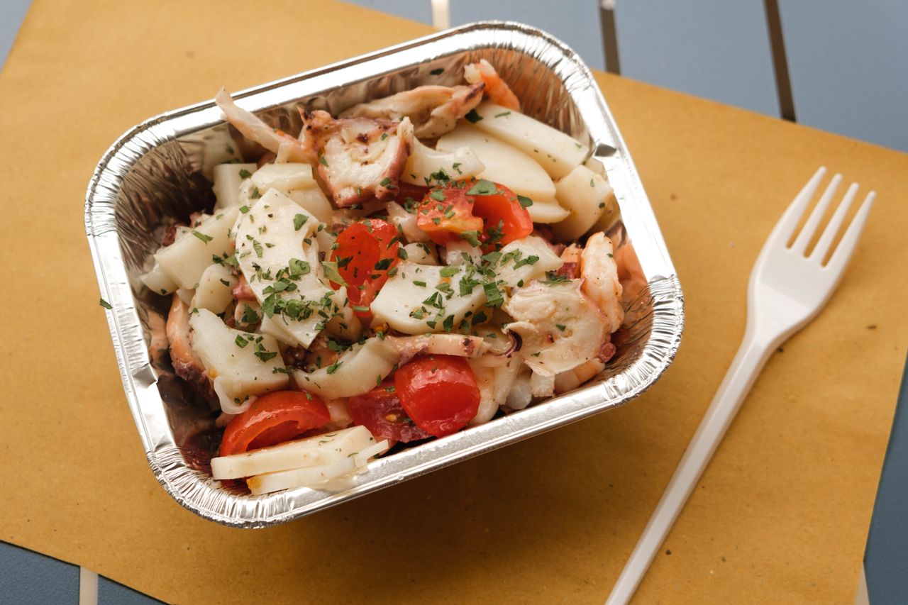 Un envase de aluminio con una ensalada lista para comer